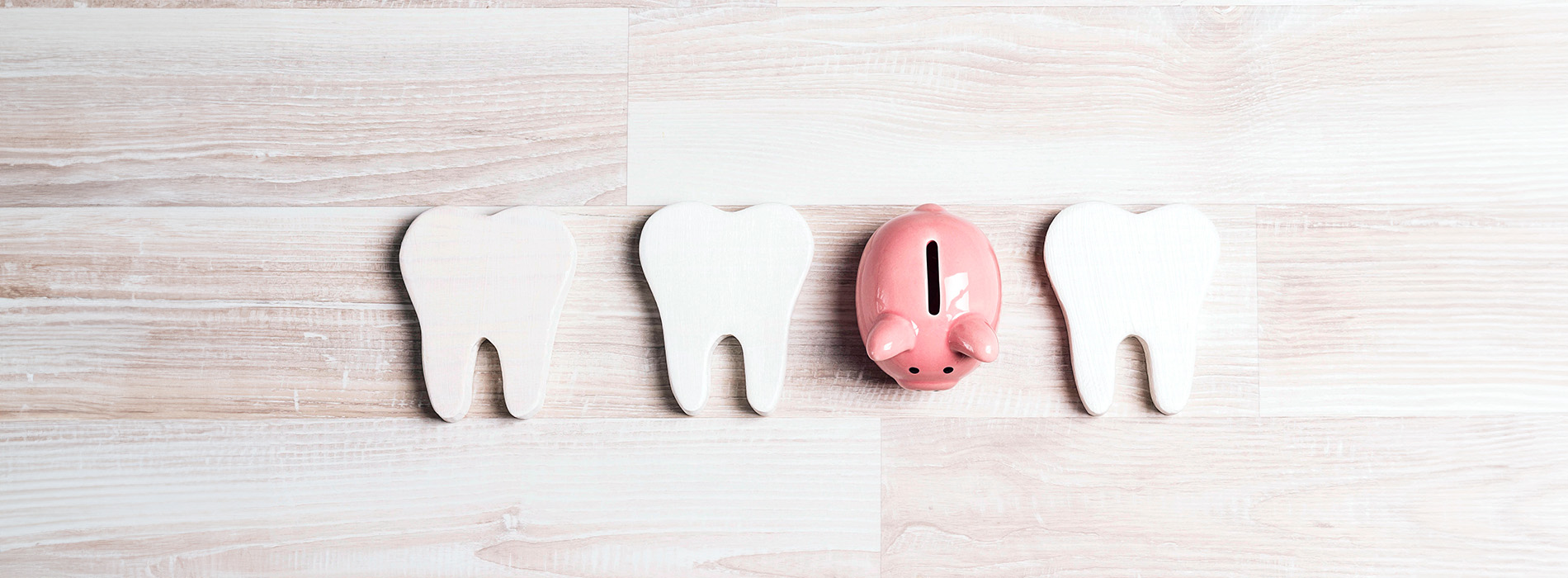 Three toothbrush holders arranged in a triangle on a white surface, with a pink piggy bank placed on top.