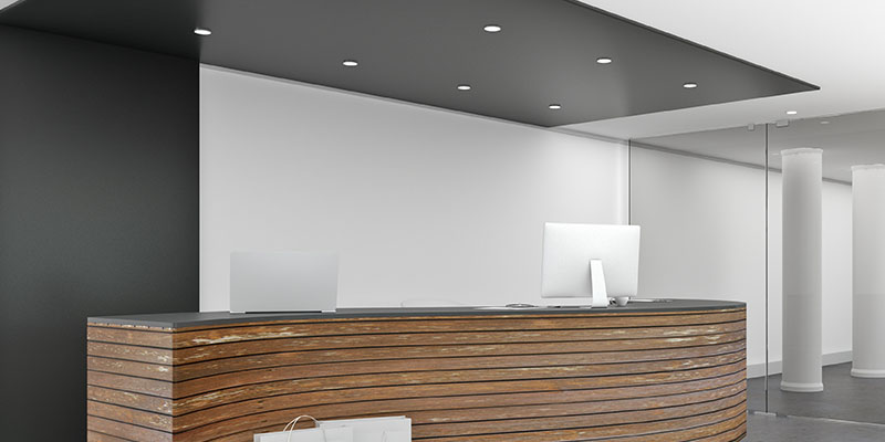 The image depicts a modern office reception area with a sleek, contemporary design featuring a wooden desk and a white countertop.