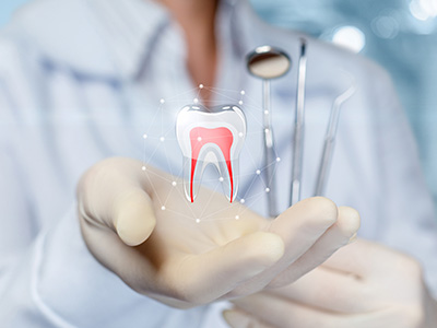 The image depicts a hand holding a tooth with a cavity, surrounded by various dental instruments and a toothbrush.